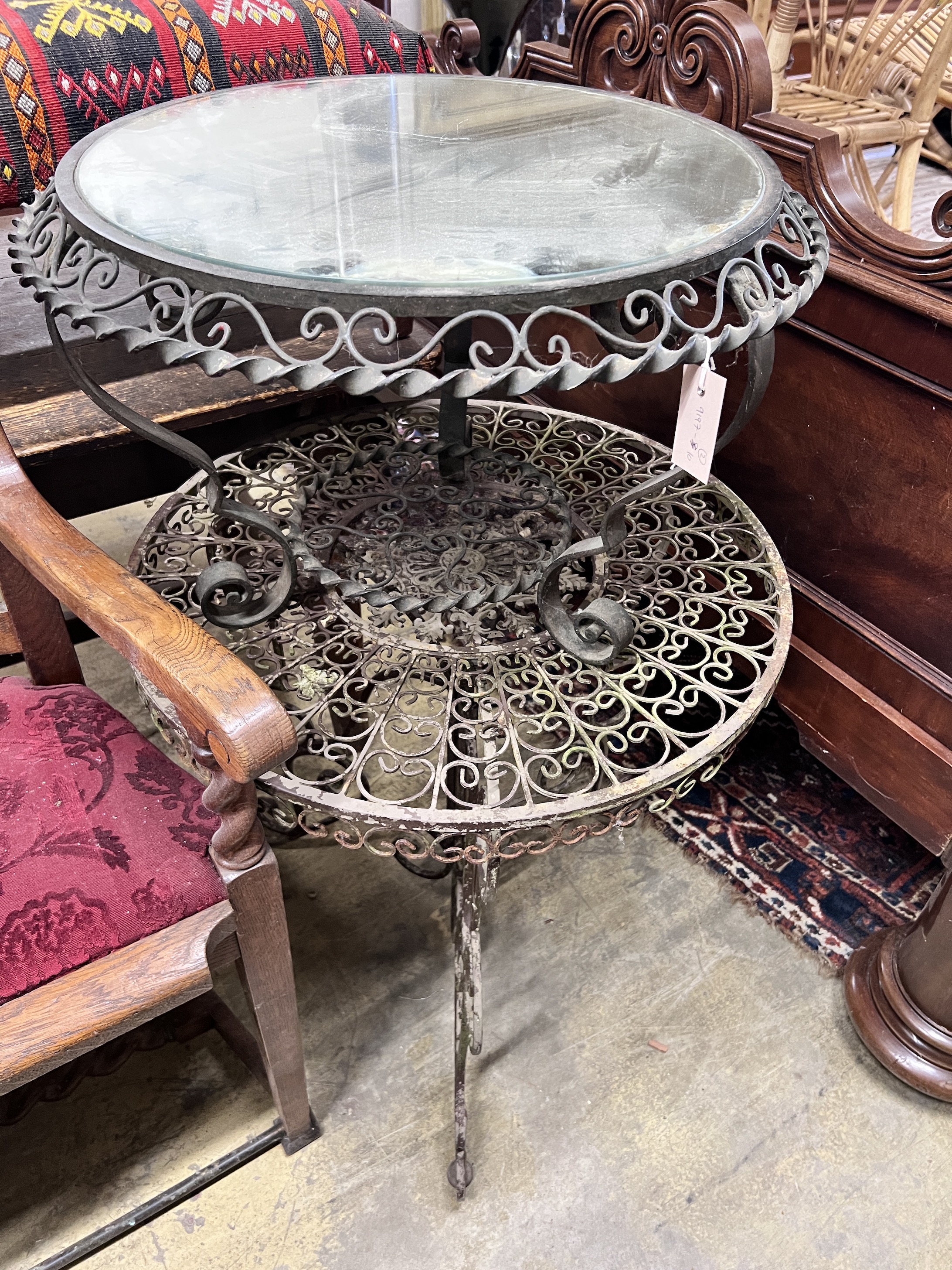 A wrought iron garden table, diameter 69cm and a similar low table with mirrored top, diameter 63cm